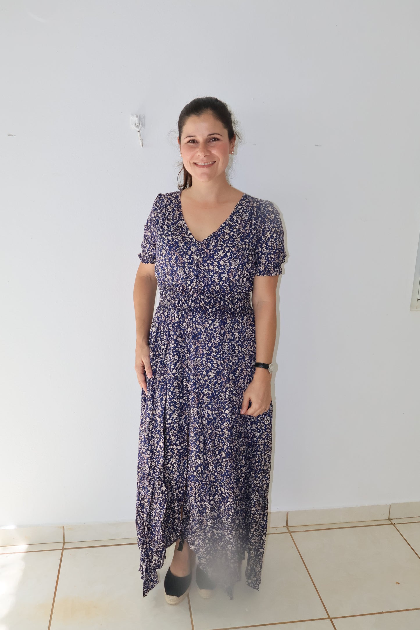 Navy floral maxi dress with a smocked stretch waistline and three-quarter sleeves, featuring a button-up front.