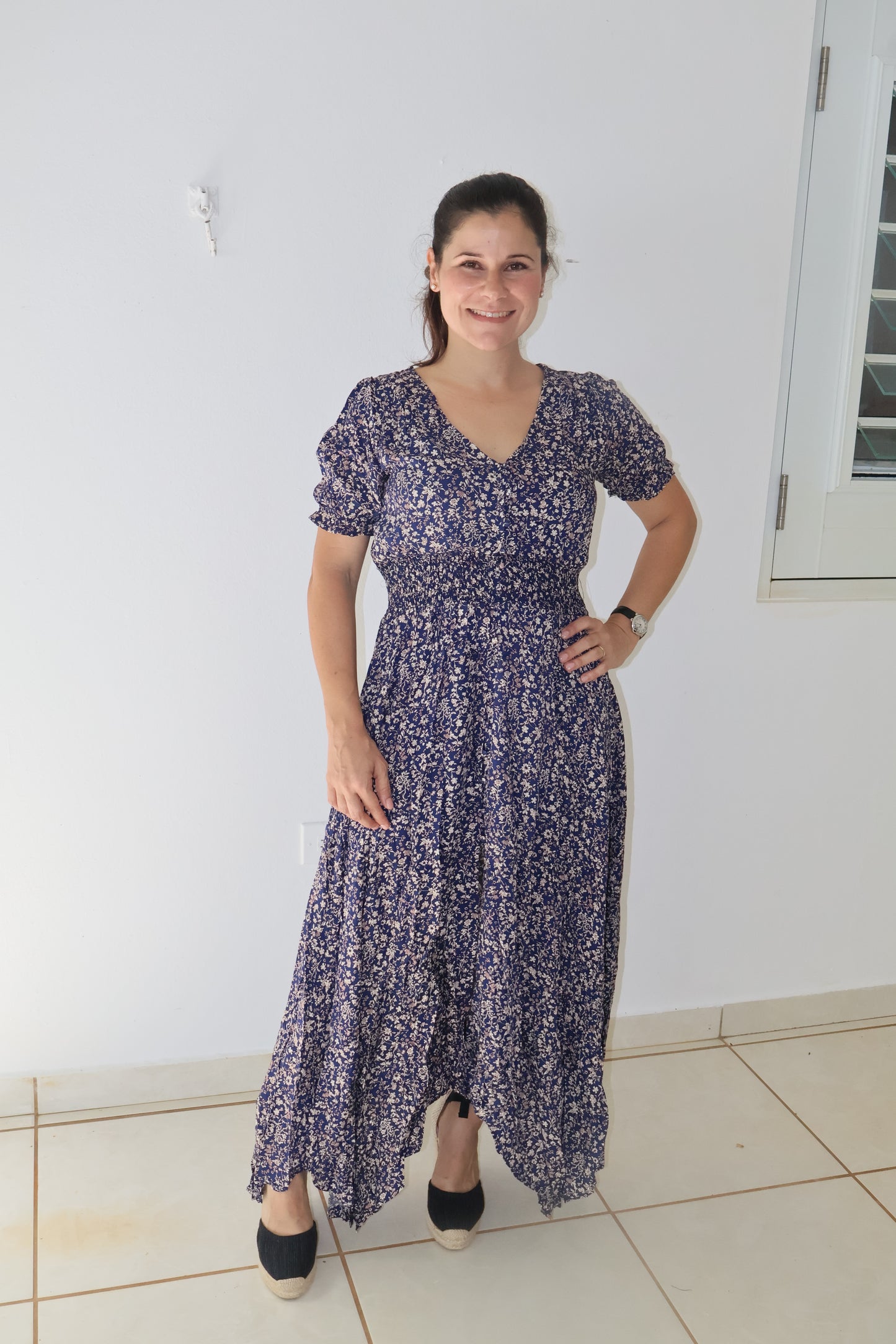 Navy floral maxi dress with a smocked stretch waistline and three-quarter sleeves, featuring a button-up front.