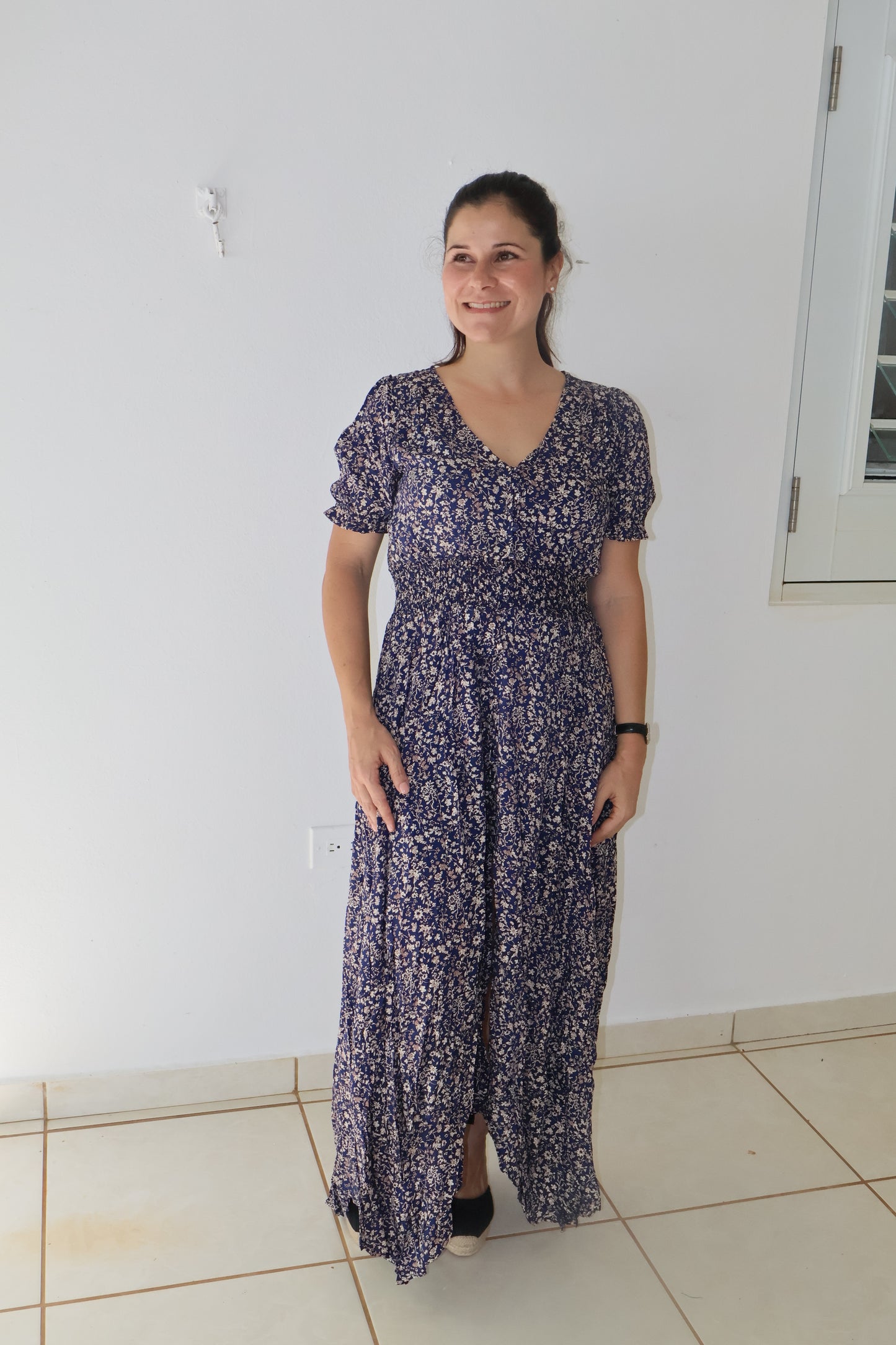 Navy floral maxi dress with a smocked stretch waistline and three-quarter sleeves, featuring a button-up front.