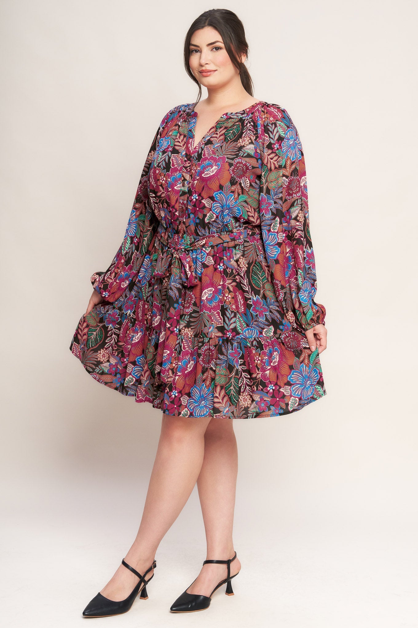 Plus Size Woman wearing a floral dress on a plain background