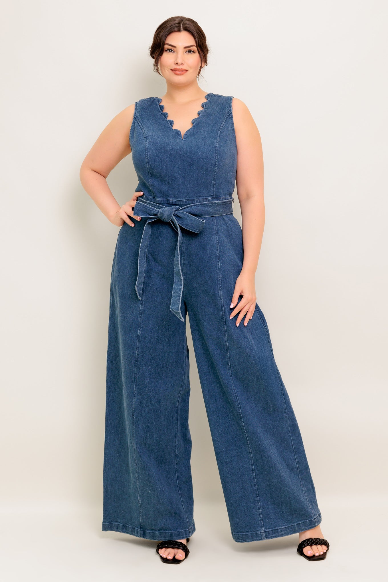 Woman wearing a blue denim jumpsuit on a white background