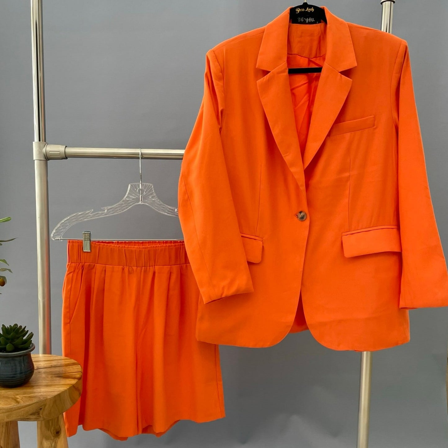 orange color blazer and orange shorts.