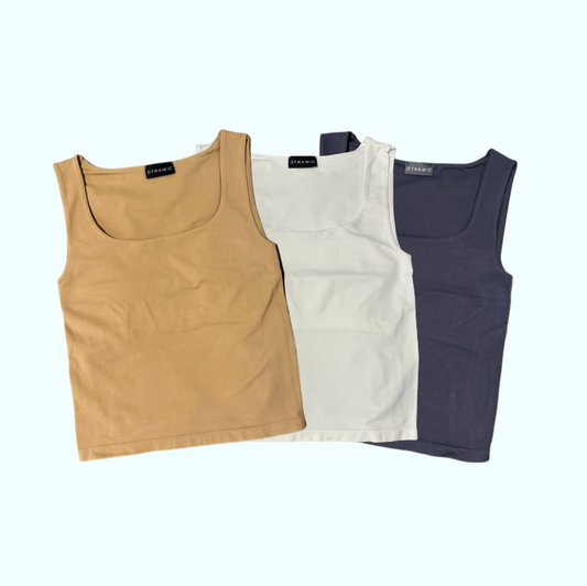 Three tank tops in beige, white, and navy on a white background