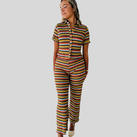 Person wearing a colorful striped outfit on a plain background