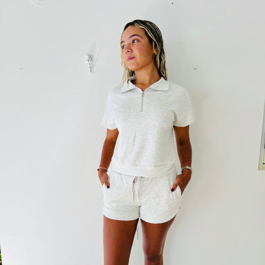 Woman wearing a white outfit against a white wall