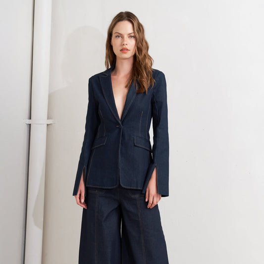 Woman wearing a navy blue suit with wide-leg pants on a white background