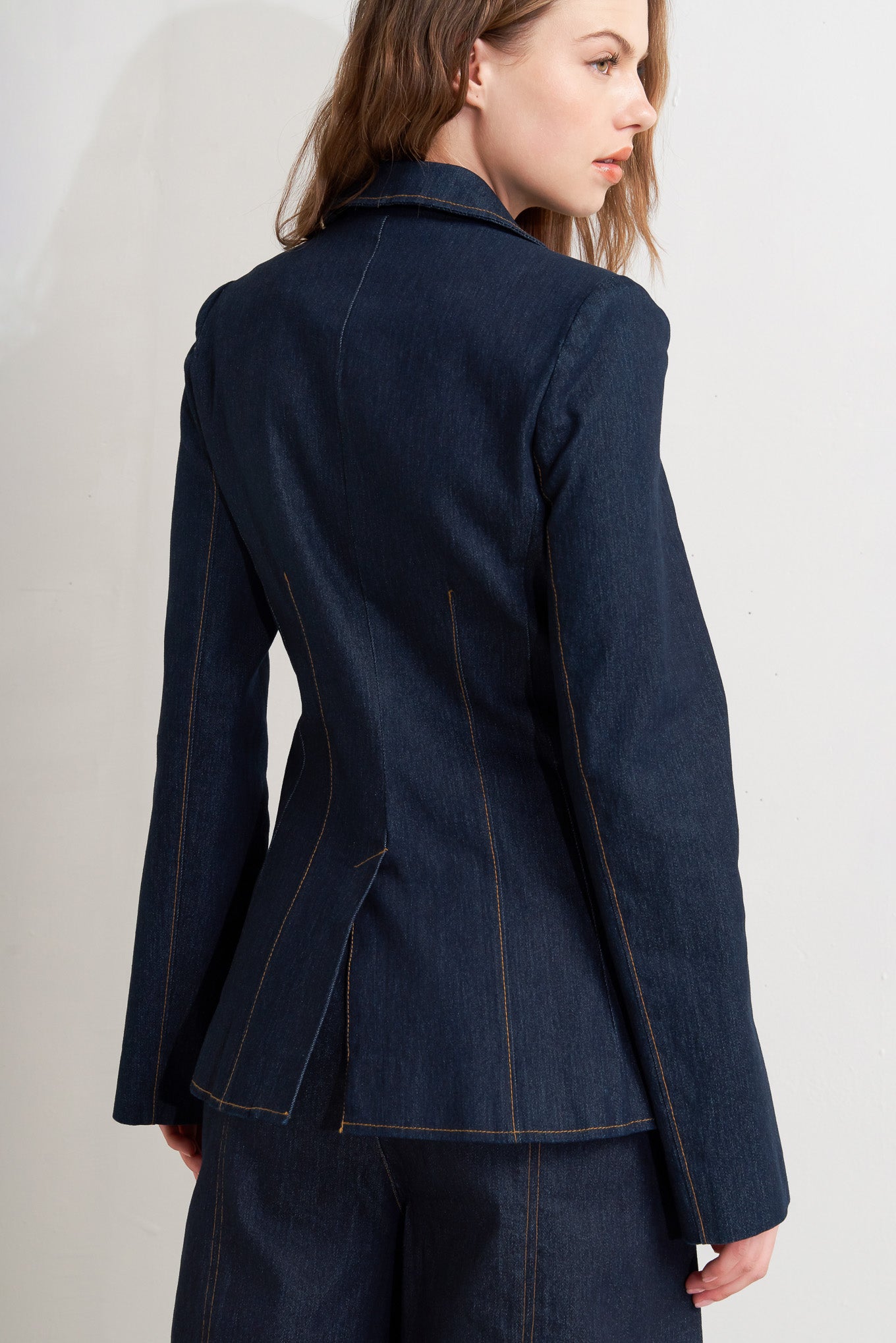 Woman wearing a dark blue jacket on a plain background