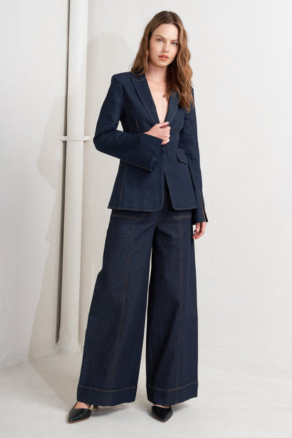 Woman wearing a navy blue suit with wide-leg pants on a white background