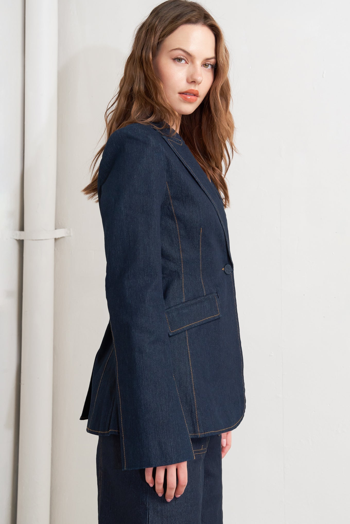 Woman wearing a dark blue blazer against a white background