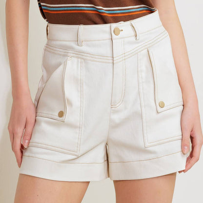 Person wearing a brown striped shirt and white shorts on a plain background