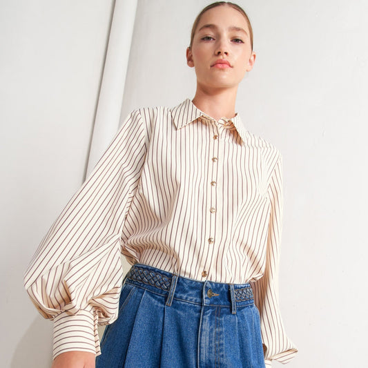 Person wearing a striped shirt and blue jeans against a white background