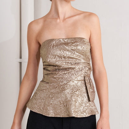 Champagne gold textured strapless peplum top with side twist detail and metallic finish for cocktail parties and celebrations