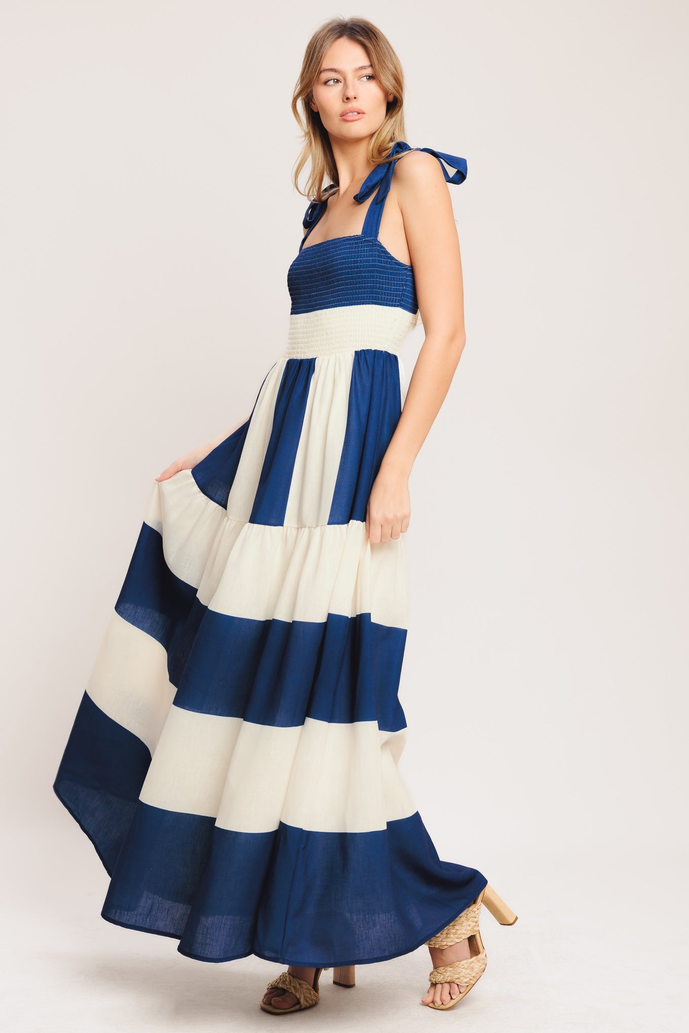 Woman wearing a blue and white striped dress on a plain background