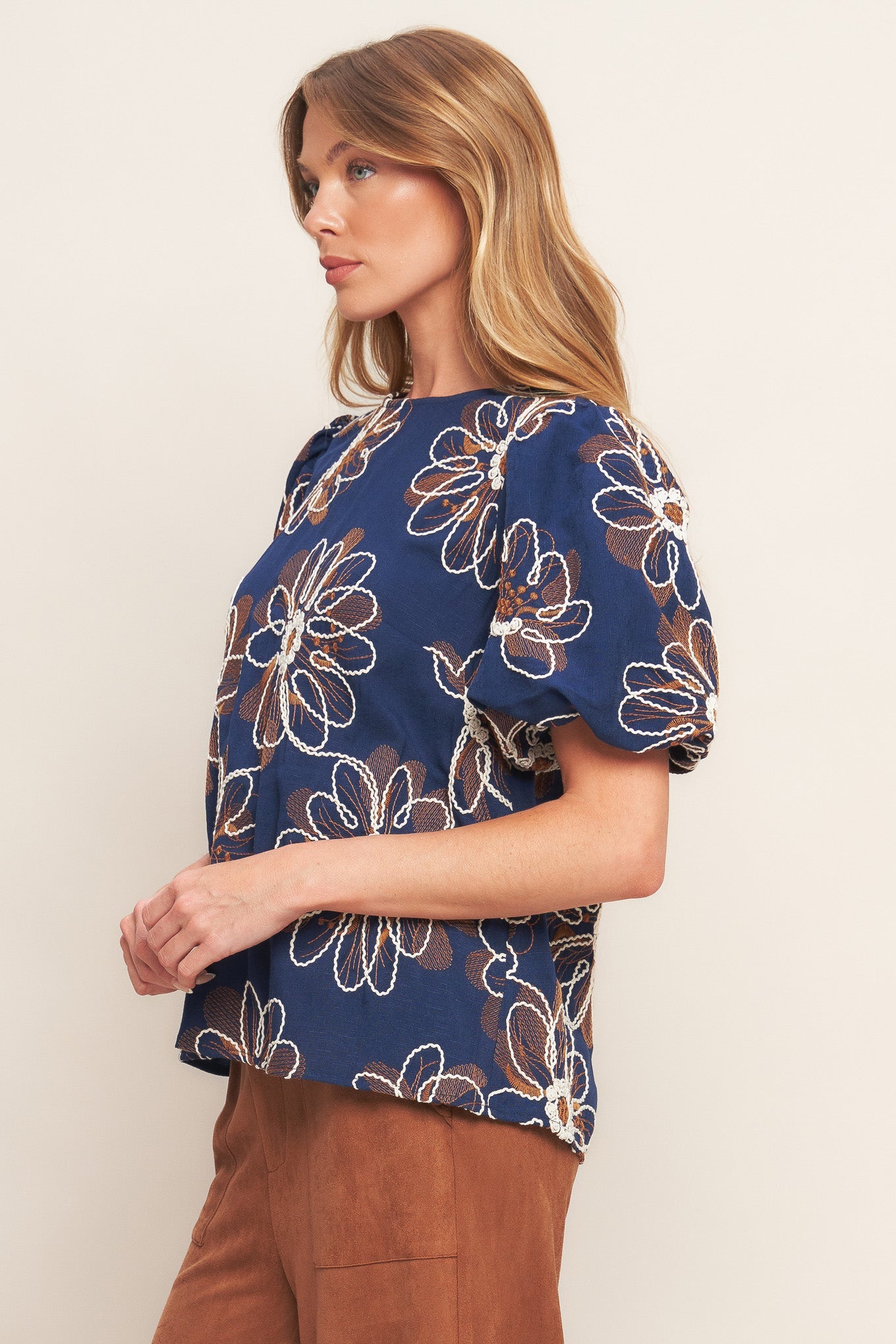 Woman wearing a blue floral blouse against a plain background