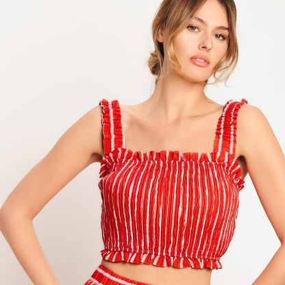 Woman wearing a red and white striped outfit on a plain background