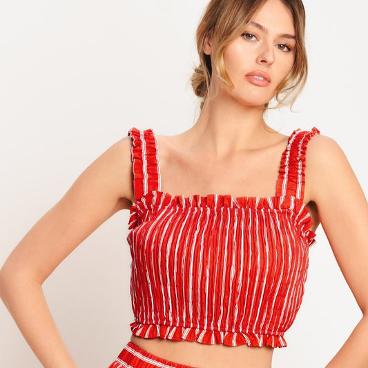 Woman wearing a red and white striped outfit on a plain background