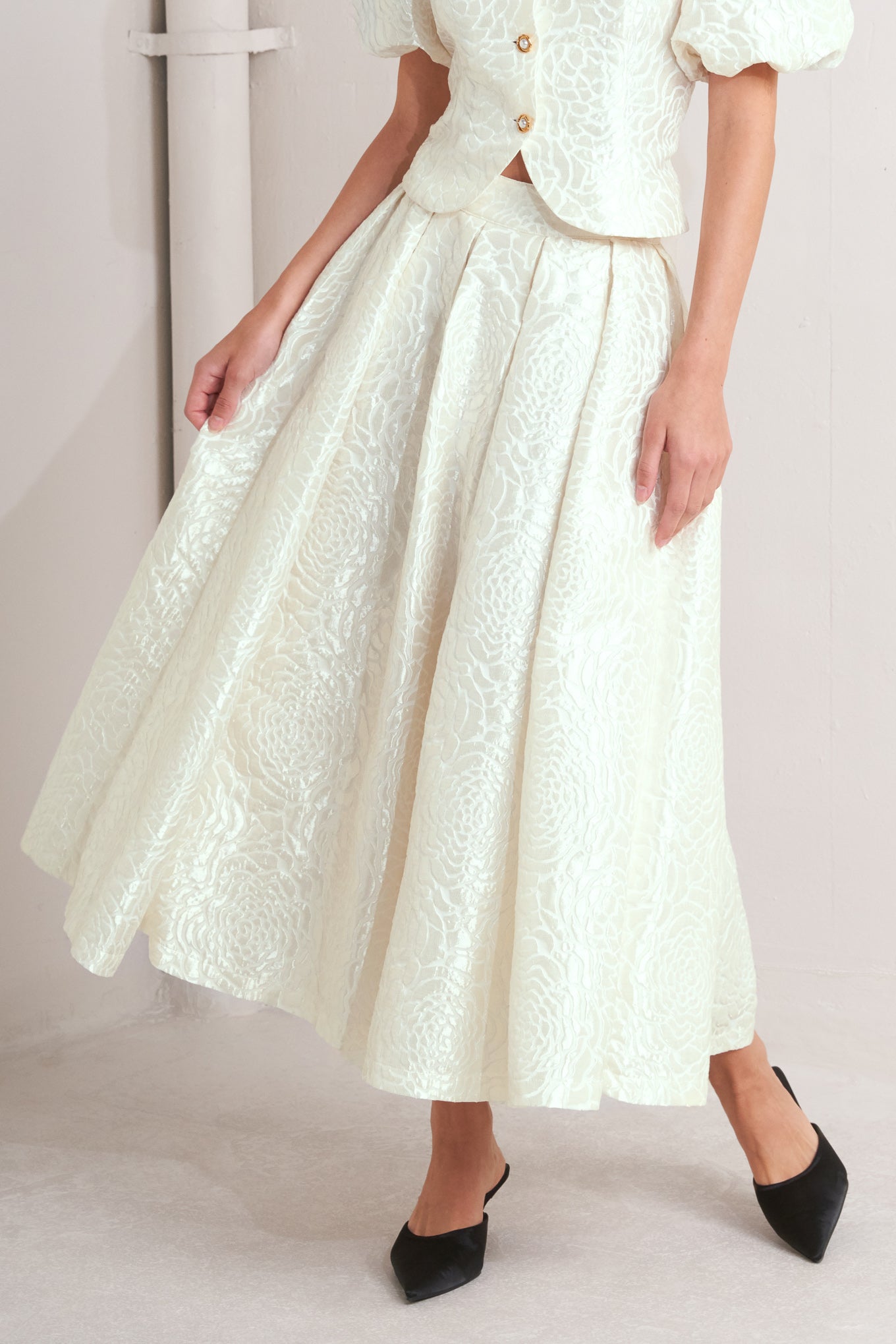 White jaquard print skirt worn by a person on a plain background