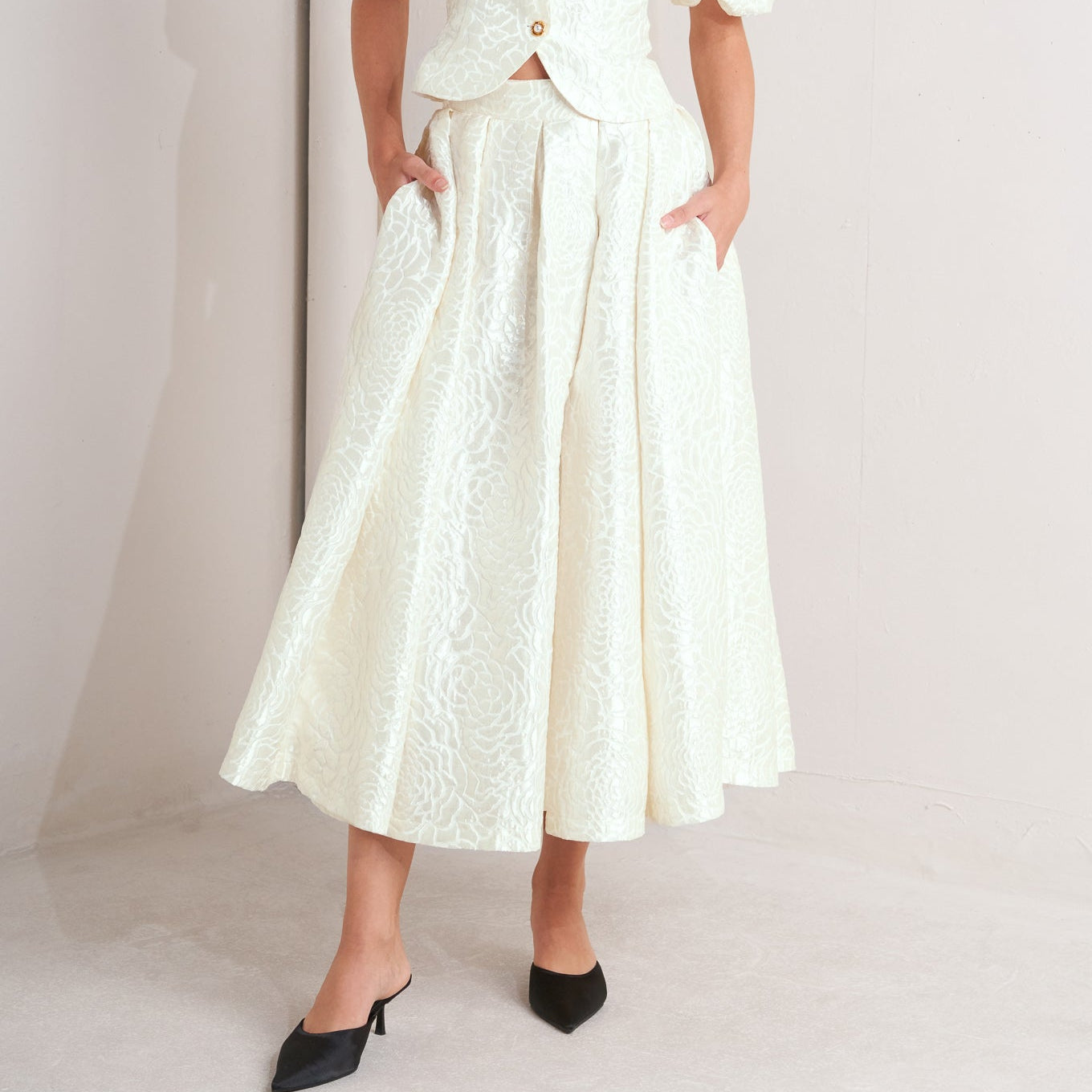 Ivory textured jacquard pleated midi skirt with high waist and box pleats
