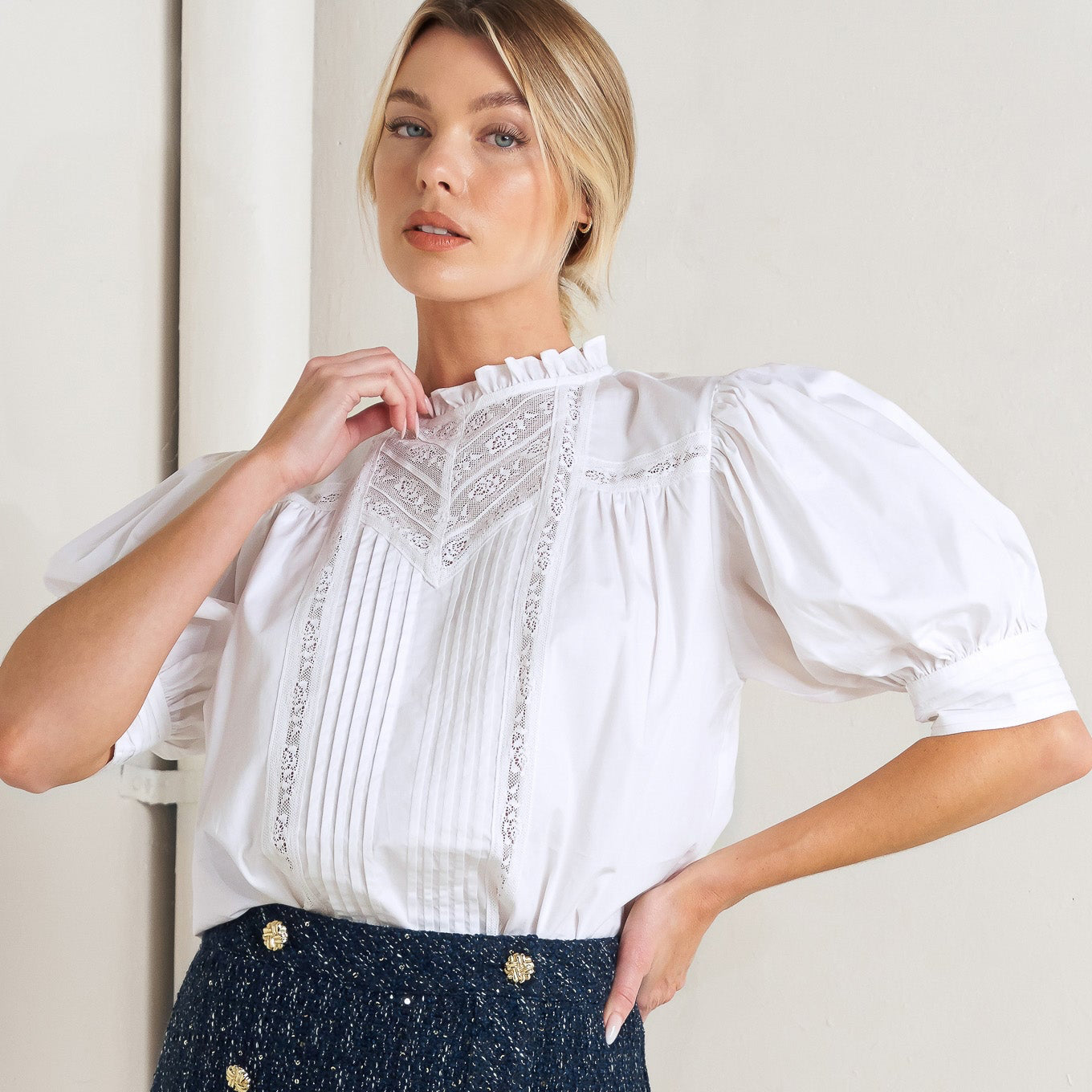 Woman wearing a White Victorian-style blouse with ruffle high neck, lace insets, pin tucks, and puff sleeves for romantic occasions
This enchanting blouse captures the romance of vintage Victorian styling with modern wearability, offering a sophisticated piece that brings heirloom-quality elegance and timeless feminine charm to special occasions and everyday sophistication.​​​​​​​​​​​​​​​​